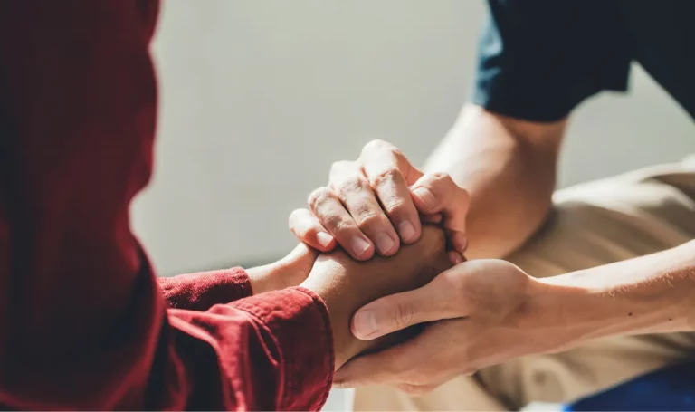 Therapeut hält Hand von Patient